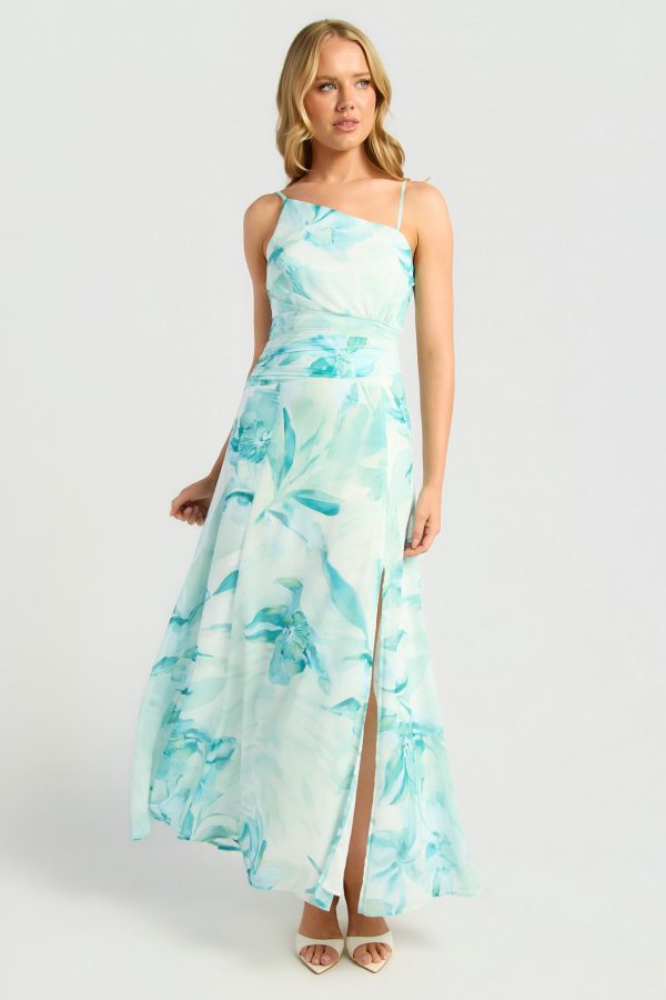 KoKo Jade Bloom maxi dress with a jade and aqua floral print, asymmetric neckline, slim straps, gathered waist and side split, shown on a model