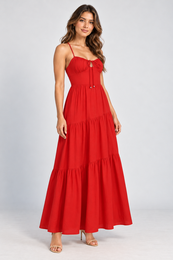 Model wearing the KoKo Scarlett Sunset red maxi dress with thin straps, a gathered tie-front neckline and flowing asymmetric skirt tiers.